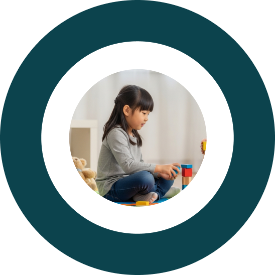 Young girl sitting on the floor playing with building blocks.