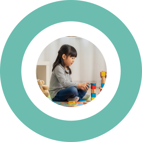 Young girl sitting on the floor playing with building blocks.