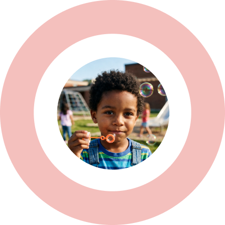 Young boy blowing bubbles on a playground.